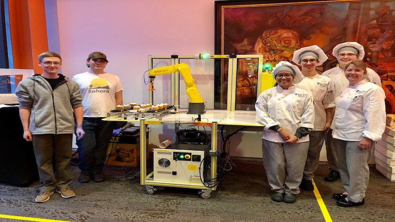 VoTech Students stand in front of the trophies they made