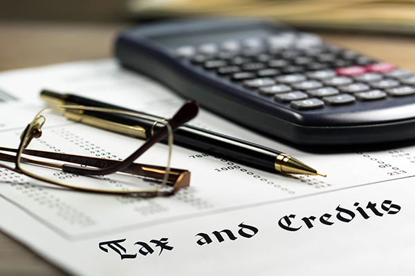 Image of calculator , pen and eyeglasses Tax and Credits